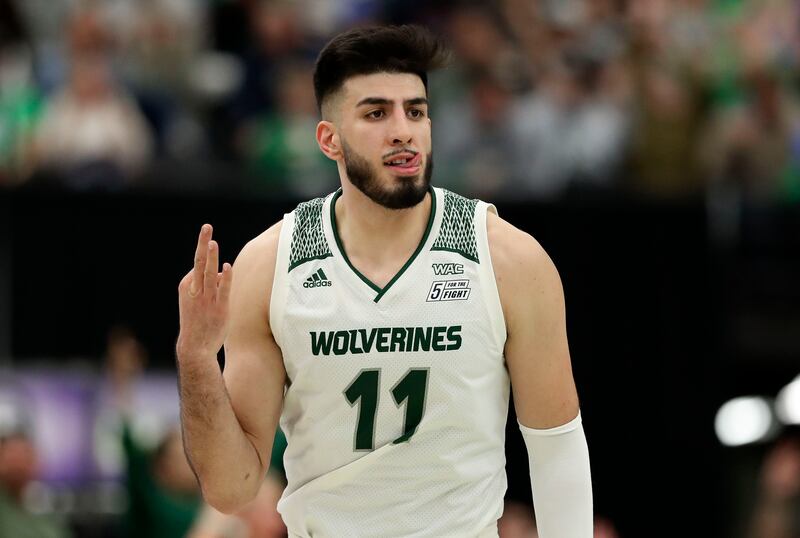 Utah Valley Wolverines center Fardaws Aimaq (11) gestures with a “3” at the BYU bench.