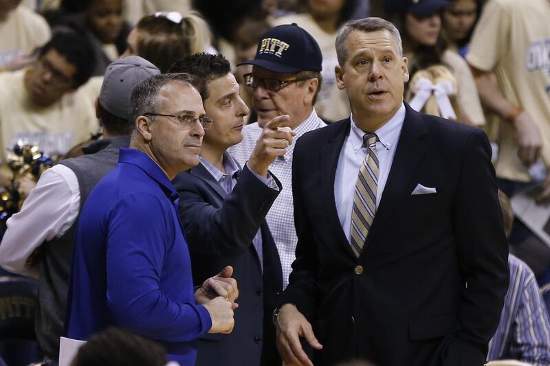 University of Pittsburgh Athletic Director Scott Barnes, right, talks with football coach Pat Narduzzi, left, before an NCAA college basketball game between Pittsburgh and Duke, Sunday, Feb. 28, 2016, in Pittsburgh. Barnes, who was also the Utah State ath