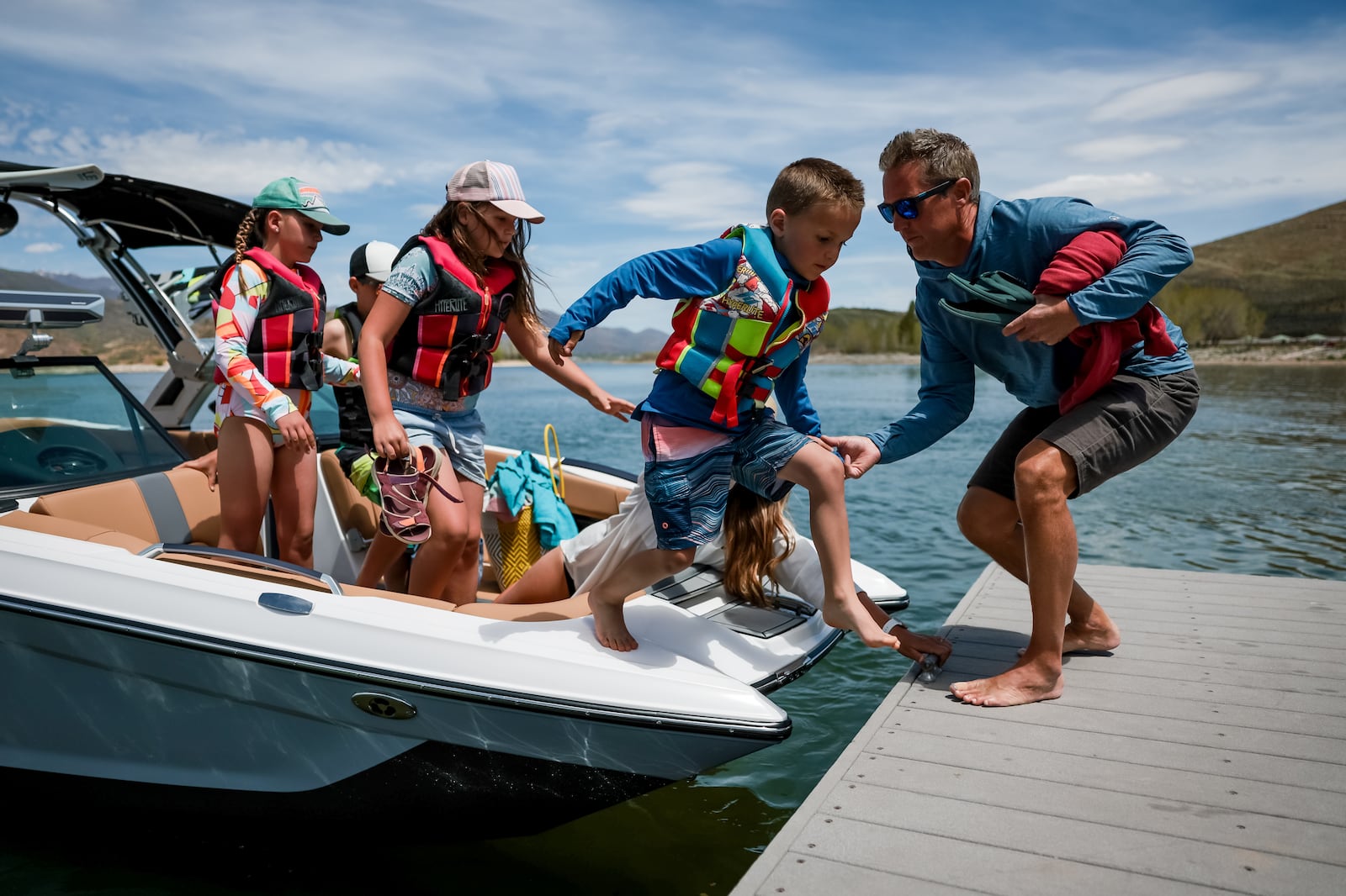 Jonathan Wagstaff, owner of Deer Creek Island Resort,, helps Gabe Allen, age 5, off a rental boat at the resort in Heber. Also on the boat are Madeline Allen, 9, Kaden Allen, 11, Evelyn Allen, 9, and their mother, Alise Allen.