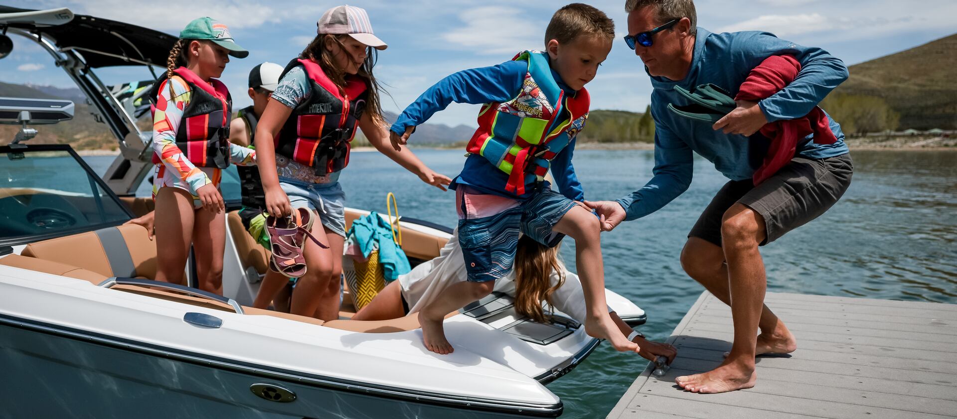 Jonathan Wagstaff, owner of Deer Creek Island Resort,, helps Gabe Allen, age 5, off a rental boat at the resort in Heber. Also on the boat are Madeline Allen, 9, Kaden Allen, 11, Evelyn Allen, 9, and their mother, Alise Allen.