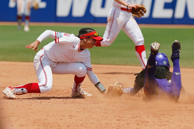 Washington’s Brooklyn Carter steals second past Utah’s Aliya Belarde during a Women’s College World Series game.