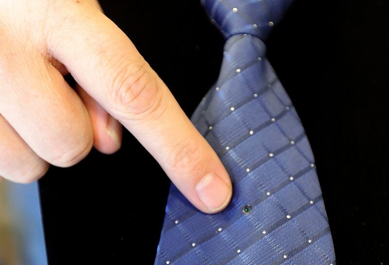 Thal Dixon points out where a spy camera is hidden in a necktie at Dixon Security Cameras in South Salt Lake on Tuesday, March 12, 2019.