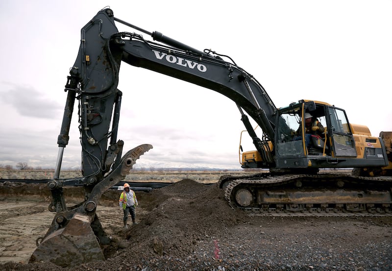 Workers repair a soft spot in the temporary haul road for the new prison in Salt Lake City on Wednesday, Feb. 22, 2017.
