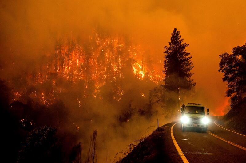 A firetruck drives along California Highway 96 as the McKinney Fire burns in Klamath National Forest, Calif.