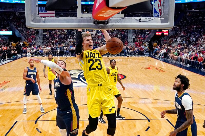 Utah Jazz forward Lauri Markkanen (23) slam dunks over New Orleans Pelicans center Jonas Valanciunas, left, and forward Brandon Ingram, right, in the first half of an NBA basketball game in New Orleans, Sunday, Oct. 23, 2022. (AP Photo/Gerald Herbert)
