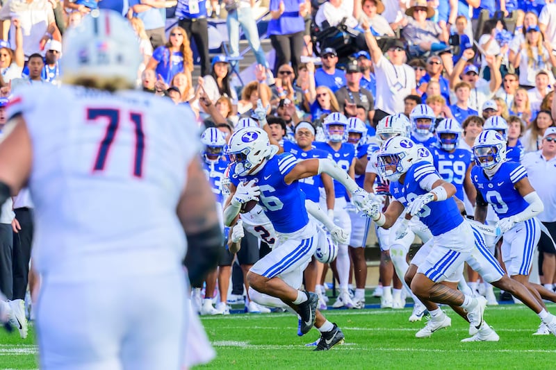 BYU linebacker Isaiah Glasker, center, heads up field for a pick-six during game against Arizona on Saturday, Oct. 12, 2024, in Provo, Utah.