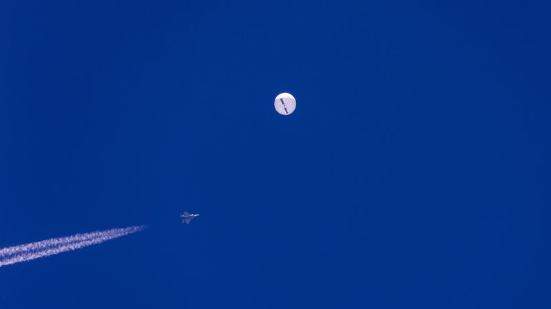 A fighter jet flies near a large balloon drifting above the Atlantic Ocean, just off the coast of South Carolina, Feb. 4, 2023.