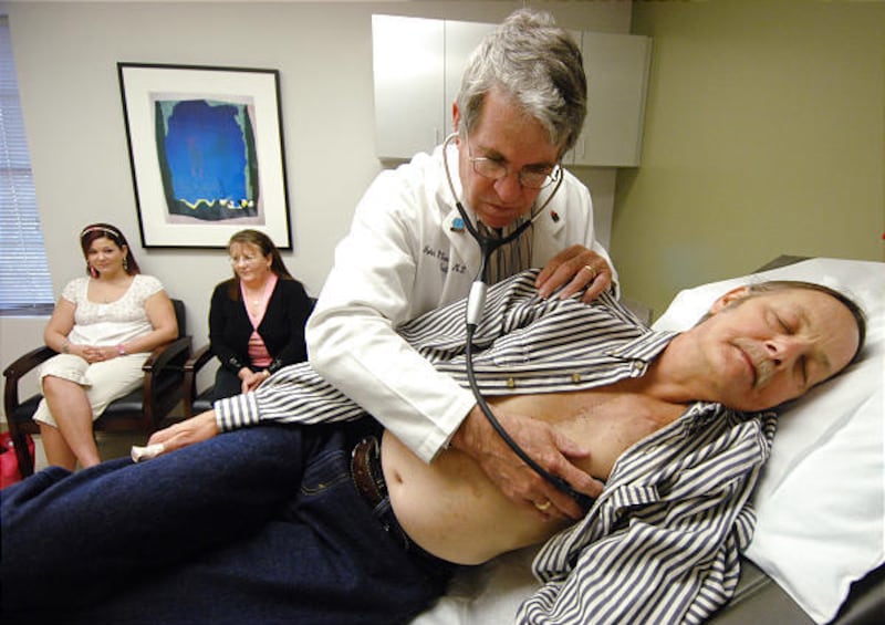 Cardiologist Dr. John Thornton examines James Kennedy as Kennedy's daughter, Brittany, left, and wife Debra watch in Augusta, Ga. When Kennedy suffered a heart attack last summer, his daughter used a home defibrillator to revive him.