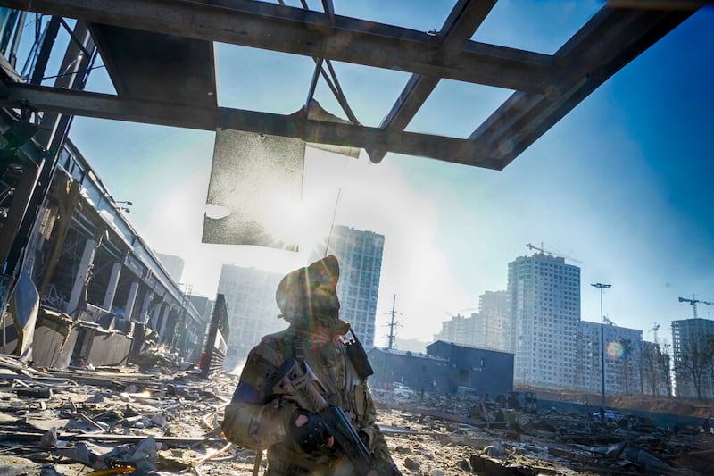 A Ukrainian soldier stands on the ruins in Kyiv.