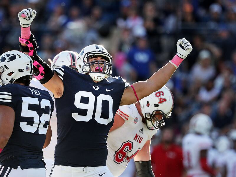 Brigham Young Cougars defensive lineman Corbin Kaufusi celebrates after the Brigham Young Cougars stop the Northern Illinois Huskies on third down during NCAA football in Provo on Saturday, Oct. 27, 2018. At lower right is Northern Illinois Huskies quarte