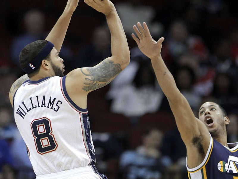 New Jersey Nets' Deron Williams (8) shoots against Utah Jazz's Devin Harris in the first quarter of an NBA basketball game, Monday, March 26, 2012, in Newark, N.J. (AP Photo/Julio Cortez)