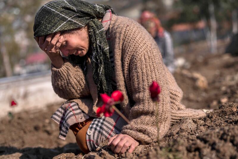 A member of the Vehibe family mourns a relative during the burial of one of the earthquake victims that struck a border region of Turkey and Syria.
