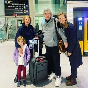 A family looking stressed and frustrated at an airport, surrounded by luggage