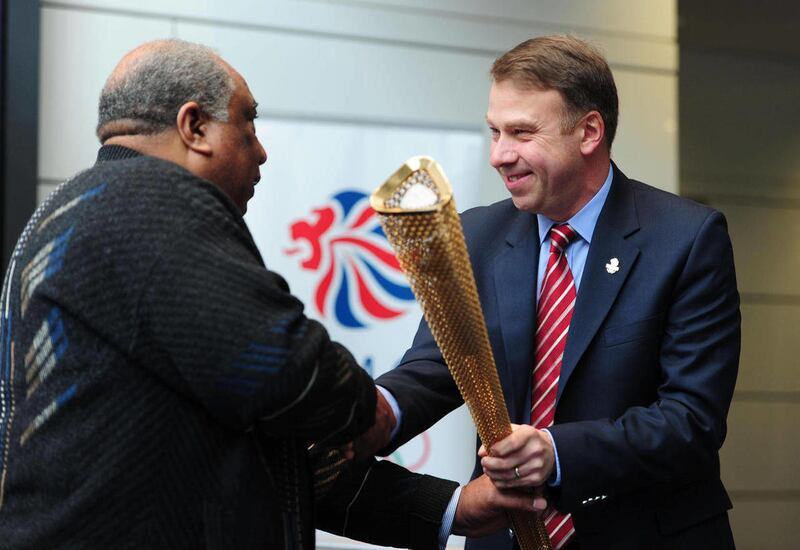 Andy Hunt Team GB Chef de Mission and British Olympic Association CEO, right, hands over the Olympic Torch to Jim Redmond who was nominated by Andy Hunt to carry the Olympic Flame during the London 2012 Torch Relay, during an event at Wembley Stadium, L