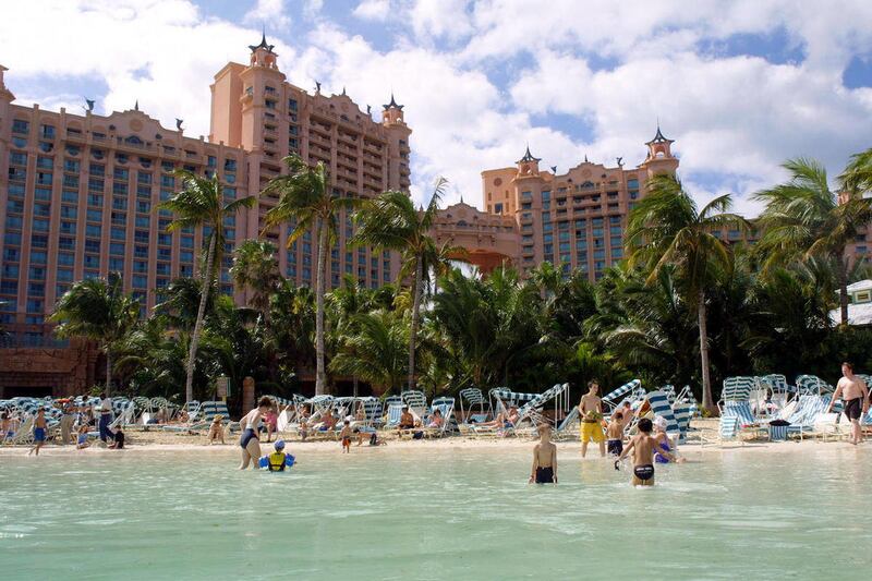 FILE - In this April 27, 2007 file photo provided by Atlantis on Paradise Island, guests at the Atlantis hotel swim on Paradise Island, Bahamas. Resort company Kerzner International said Tuesday Nov. 29, 2011 that it would transfer ownership of one of th