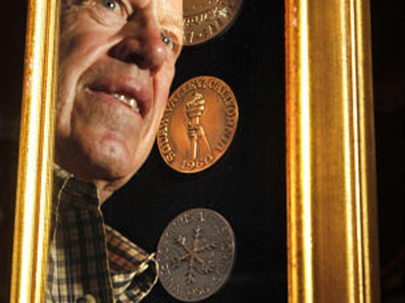 Former Olympic skier Marvin Melville poses with some of his awards he received over his career.