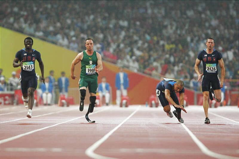 Tremonton's Marlon Shirley falls during the 100-meter finals as South Africa's Oscar Pistorius of South Africa, second from left, wins the gold.