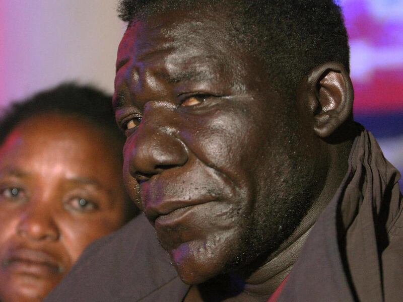 In this photo taken Tuesday, May 29, 2012, William Masvinu, winner of the Mr Ugly competition poses for a photo with his wife Alice at a local club in Harare. Masvinu, 38, who won the second edition of the pageant last month, makes his living carrying lo