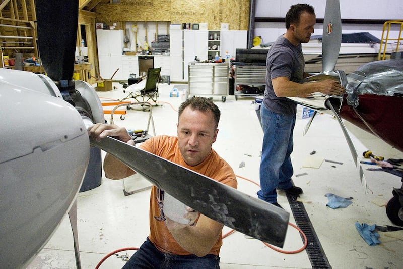Mike Patey, left, and his twin brother, Mark, work side by side on their Lancair Legacy planes that they built and custom modified from a kit on March 29, 2011 in their hanger at the Spanish Fork, Utah Airport.