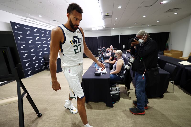 Utah Jazz center Rudy Gobert, wearing a white jersey, exits after an interview during the Utah Jazz media day at Vivint Arena in Salt Lake City.