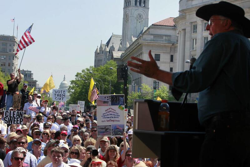With the Capitol in the background, former House Majority Leader Dick Armey addresses a Tea Party rally at Freedom Plaza in Washington, Thursday, April 15, 2010.