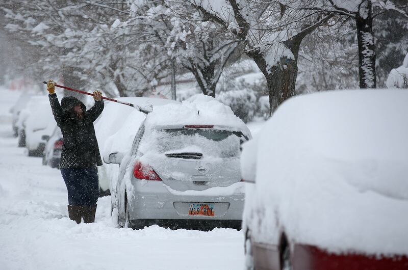 Heather Parrish clears off her car during a snow storm in Salt Lake City on Wednesday, Feb. 6, 2019.