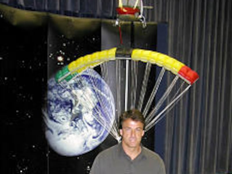 Dan Rudert stands before a NASA model of the helicopter capture of the Genesis space capsule. He will participate in the Sept. 8 mission.