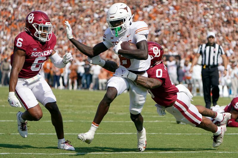 Texas wide receiver Xavier Worthy (8) runs against Oklahoma defensive backs Woodi Washington (0) and Trey Morrison (6)