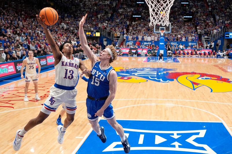 Kansas guard Elmarko Jackson (13) shoots over BYU guard Richie Saunders (15) during the first half of an NCAA college basketball game Tuesday, Feb. 27, 2024, in Lawrence, Kan.