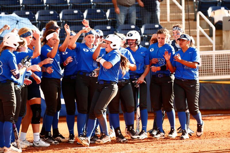 The BYU softball team greets Ashley Godfrey (front-center) after a home run in a fall game.