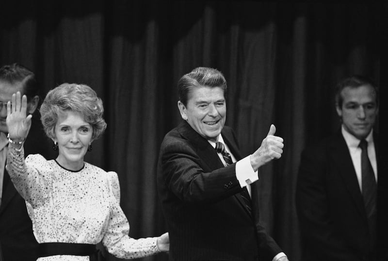 Nancy and Ronald Reagan signal to well-wishers and supporters at the Century Plaza Hotel at night, Tuesday, Nov. 7, 1984 in Los Angeles after Reagan was declared the winner in the 1984 presidential election against Democratic opponent Walter Mondale. (AP