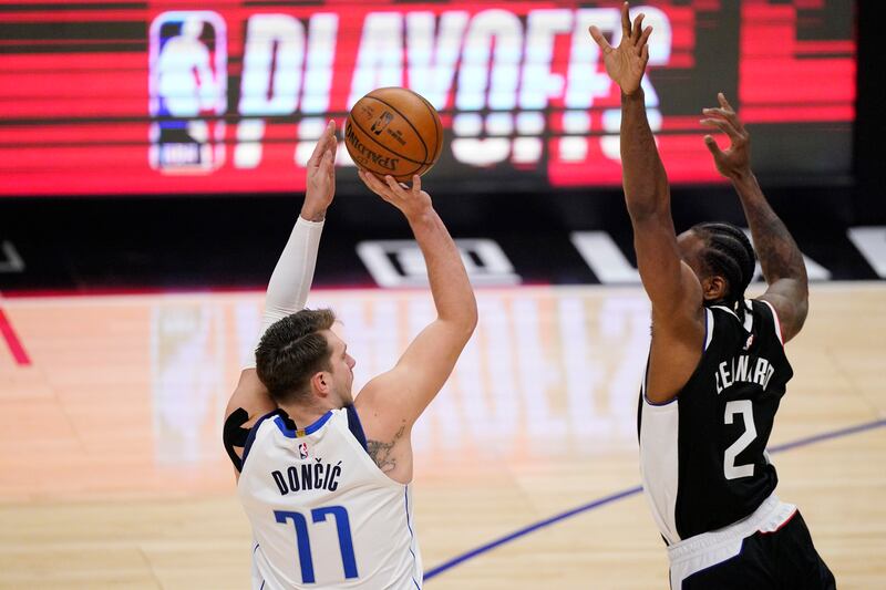 Dallas Mavericks guard Luka Doncic, left, shoots as Los Angeles Clippers forward Kawhi Leonard defends.