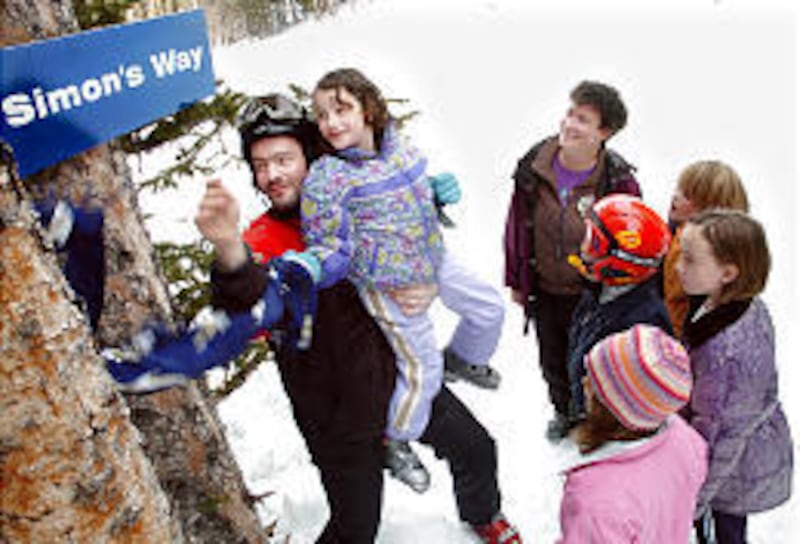 With Mary Craig and friends looking on, Markus Vodosek and daughter Miriam unveil Simon's sign.
