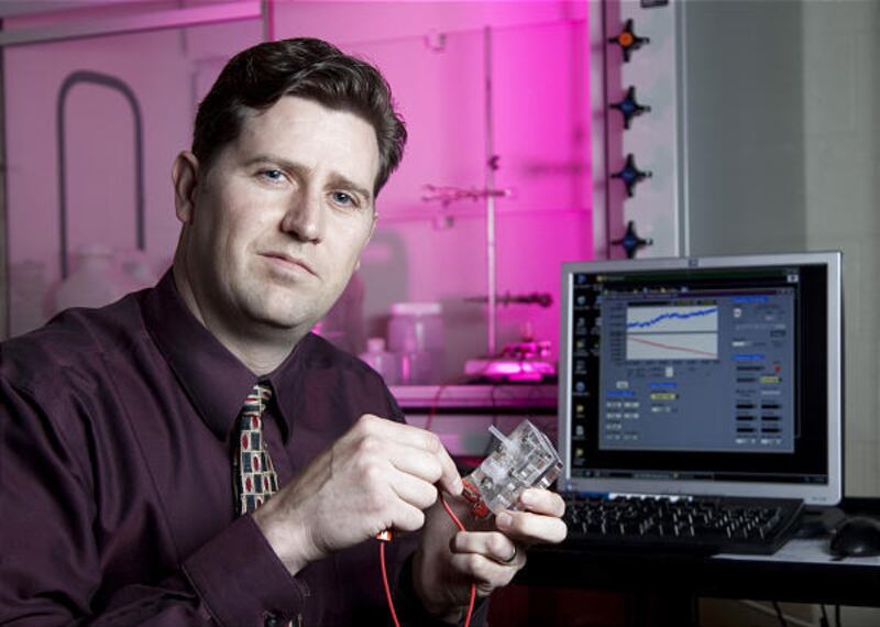 Chemical engineering professor Dean Wheeler shows a fuel cell — basically a battery with a gas tank — that harvests electricity from carbohydrates. It was developed by BYU researchers.
