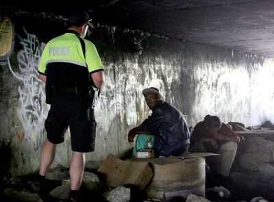 Salt Lake City police officer Chuck McNamee talks to two men hanging out under a bridge by the Jordan River in Salt Lake City on Tuesday, Aug. 14, 2018. McNamee told the two men they needed to leave the area.