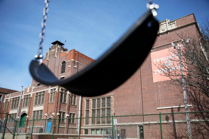 In this March 7, 2020, file photo, a swing sits empty on a playground outside Achievement First charter school in Providence, R.I.