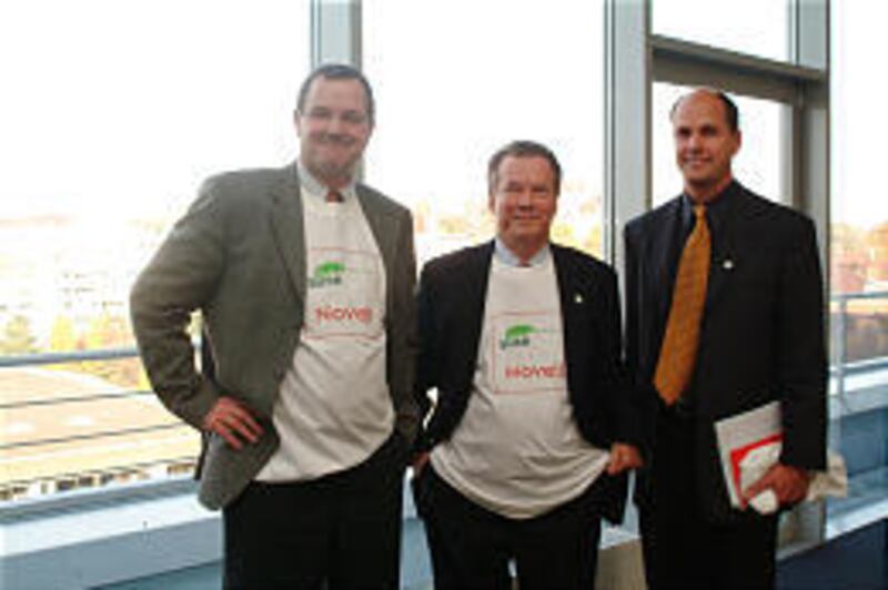 Richard Seibt, left, of SuSE Linux; Jack Messman, Chris Stone, of Novell, announce $210 million deal.