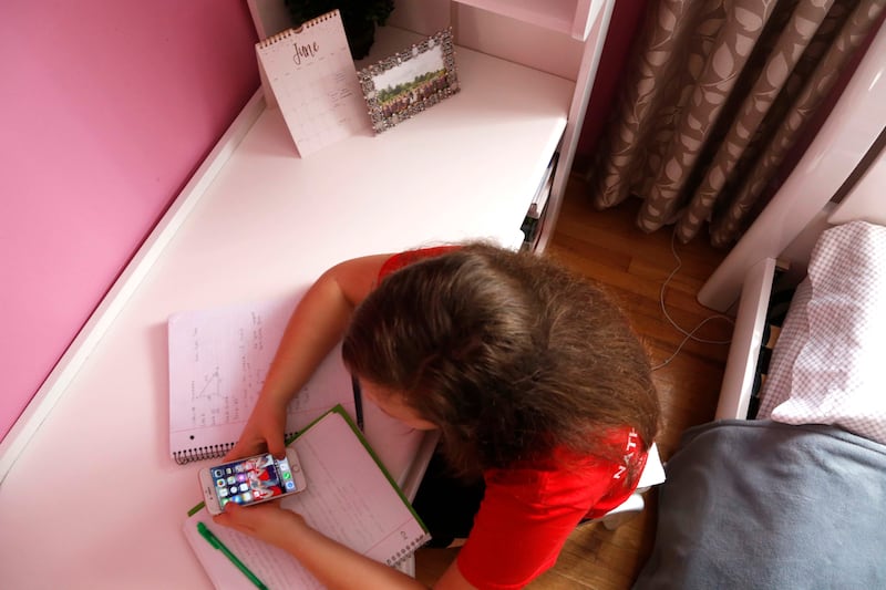 Ewelina Cudzich, 13, checks her phone in her Chicago home, Friday, June 8, 2018. Cudzich, who starts high school this fall, says she understands that parents would want to monitor a phone sometimes but thinks teens should be given more freedom as they pro