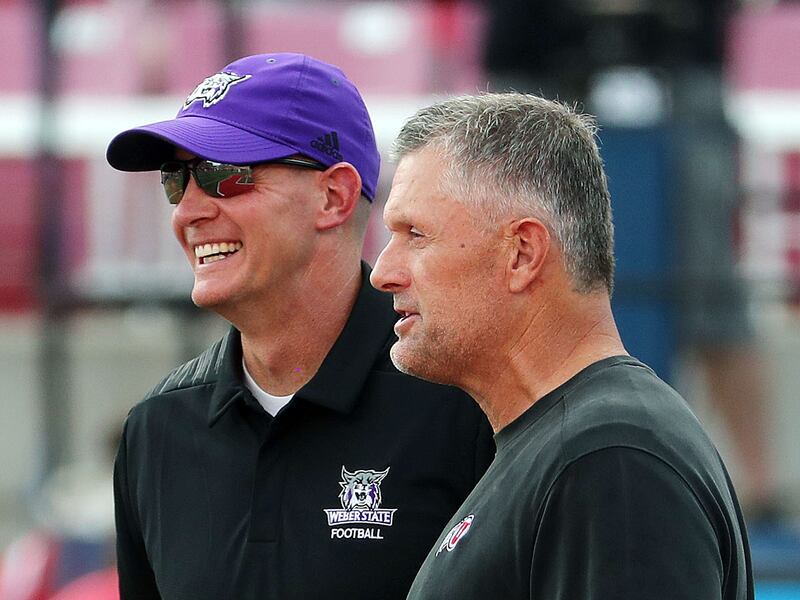 Utah Utes coach Kyle Whittingham, right, and Weber State Wildcats coach Jay Hill talk before game in Salt Lake City.