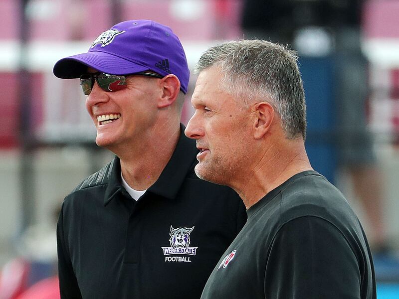 Utah Utes coach Kyle Whittingham, right, and Weber State Wildcats coach Jay Hill talk before game in Salt Lake City.