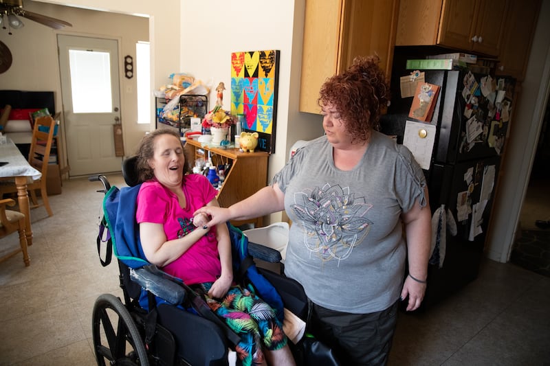 Kira Volar cares for her sister Tara, Saturday, August 4, 2018, in their home outside Sacramento, Calif. Kira is a 47-year-old full-time caregiver to her sister, who is paralyzed and has an intellectual disability. Kira has made caregiving her life's miss