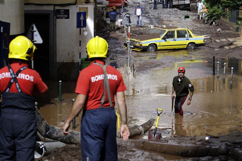 Firefighters work to pump water in downtown Funchal, the Madeira Island's capital, on Sunday.