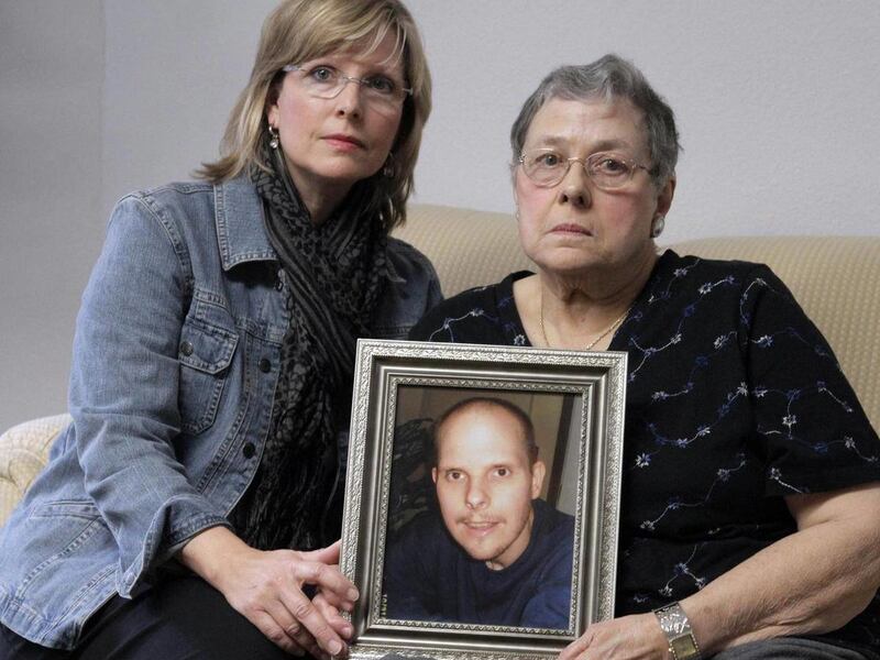 In this March 22, 2011 photo, Kathleen Slovick, left, and her mother Lois McCann, hold a photo of their brother and son Paul McCann who died of injuries he received while living in an eastern Illinois group home run by the nonprofit Graywood Foundation, i