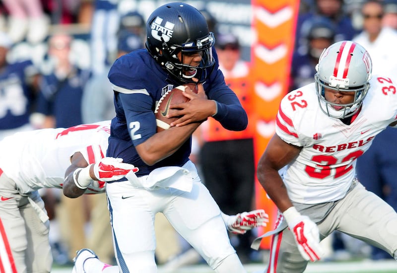 Utah State's quarterback Kent Myers (2) is tackled by UNLV's Kenny Keys during an NCAA college football game, Saturday, Oct. 25, 2014, in Logan, Utah. (AP Photo/The Herald Journal, John Zsiray)