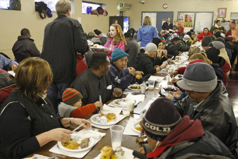 Volunteers serve steak dinners and all the trimmings with gifts for all guests for homeless and low-income individuals and families at St. Vincent de Paul Soup Kitchen with food provided by Catholic Community Services, steaks by the Church of Jesus Christ