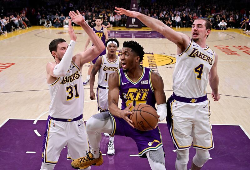 Utah Jazz guard Donovan Mitchell, second from right, passes the ball as Los Angeles Lakers forward Mike Muscala, left, forward Jemerrio Jones, second from left, and guard Alex Caruso, right, defend during the second half of an NBA basketball game Sunday, April 7, 2019, in Los Angeles.