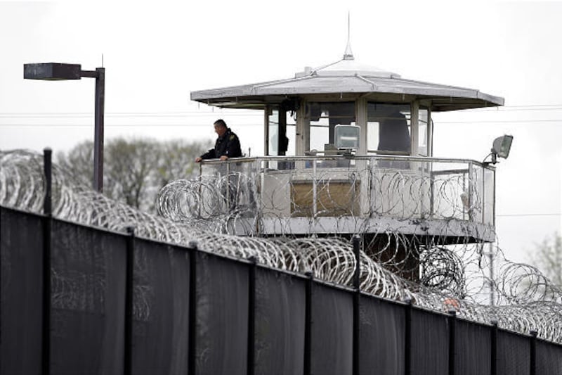 A solitary corrections officer looks out from a tower at one corner of the state prison in Camp Hill, Pa. The Pennsylvania Department of Corrections is evaluating whether it needs to have officers constantly on tower duty, since security has been enhanced