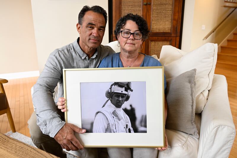 Derek and Suzi Alkonis pose with a photo of their son Lt. Ridge Alkonis on June 1, 2022, in Dana Point, Calif.