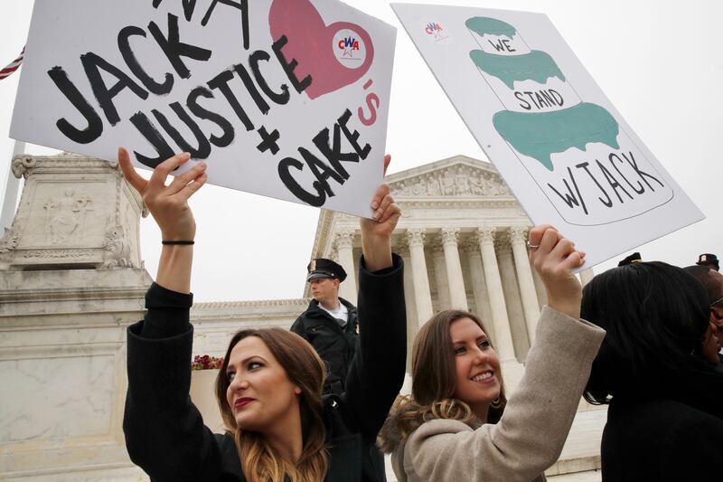 Janae Stracke, left, and Annabelle Rutledge, both with Concerned Women for America, hold up signs in support of cake artist Jack Phillips outside of the Supreme Court which is hearing the 'Masterpiece Cakeshop v. Colorado Civil Rights Commission,' Tuesday