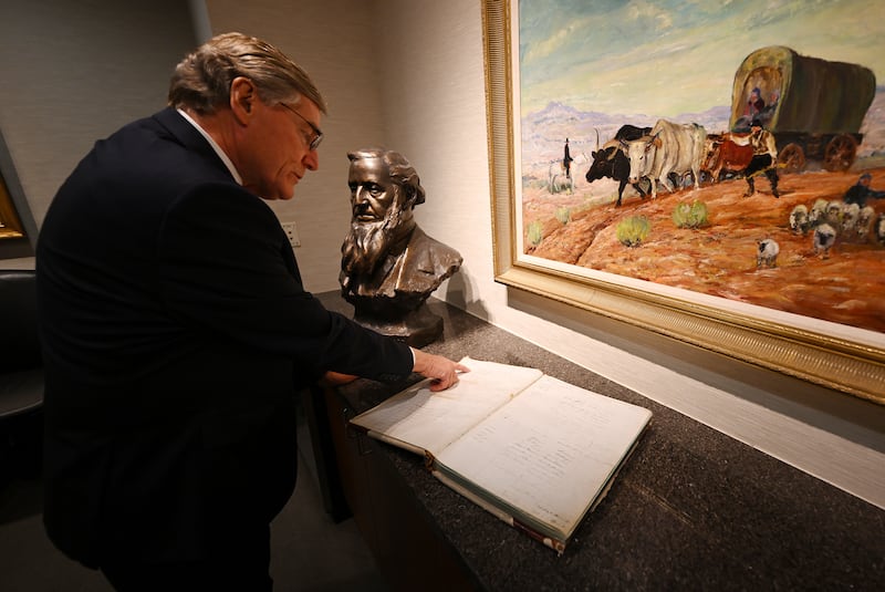 Zions Bank President CEO Scott Anderson shows signatures of Brigham Young and other leaders of The Church of Jesus Christ of Latter-day Saints in a bank ledger.